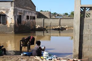 Una bambina lava le stoviglie dopo l'alluvione